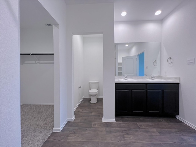 21310 Black Leaf Dr, New Caney, TX 77357 - bathroom with toilet, wood finished floors, double vanity, a spacious closet, and baseboards