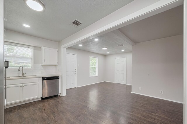 kitchen featuring stainless steel dishwasher, a sink, dark wood finished floors, white cabinetry, and light countertops