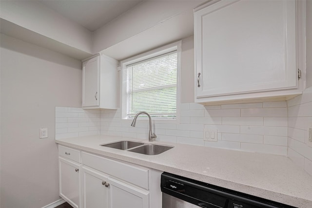 kitchen with a sink, stainless steel dishwasher, white cabinetry, and backsplash