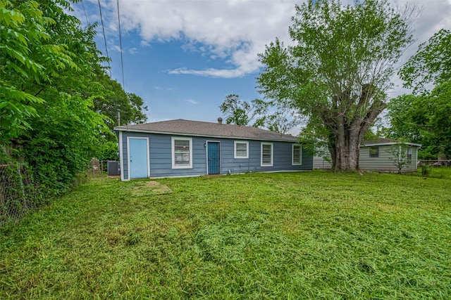 back of house with central AC and a yard