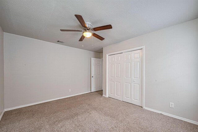 unfurnished bedroom featuring carpet flooring, a closet, baseboards, and a ceiling fan