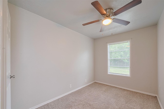 spare room featuring carpet flooring, baseboards, and ceiling fan