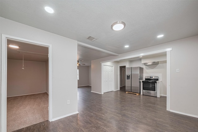 unfurnished living room featuring attic access, dark wood-type flooring, baseboards, a textured ceiling, and recessed lighting
