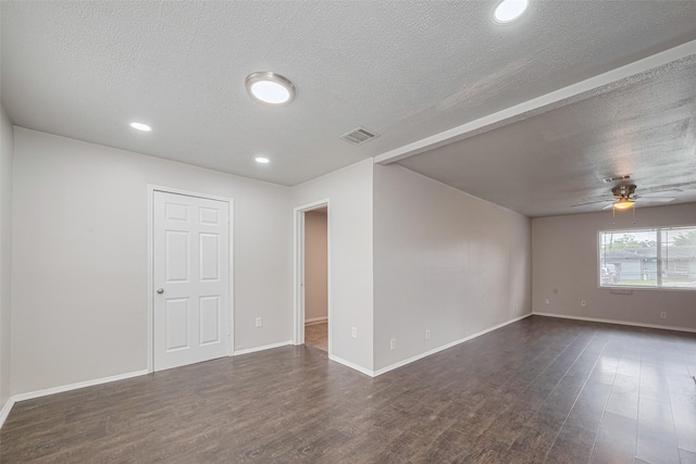 spare room featuring dark wood-style flooring, a ceiling fan, a textured ceiling, baseboards, and recessed lighting