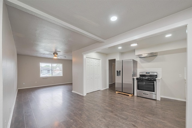 kitchen with appliances with stainless steel finishes, under cabinet range hood, dark wood-type flooring, baseboards, and a ceiling fan