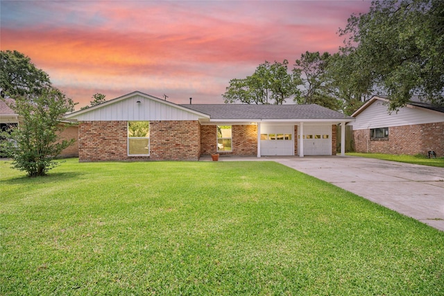 single story home with a garage, brick siding, a yard, and concrete driveway
