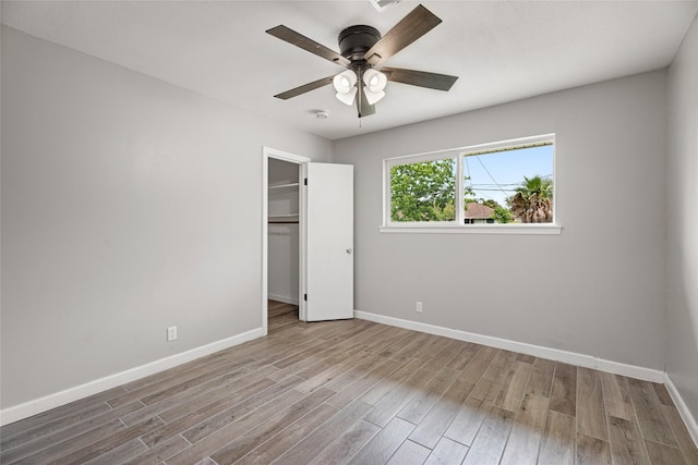 unfurnished bedroom featuring wood finished floors, baseboards, and ceiling fan