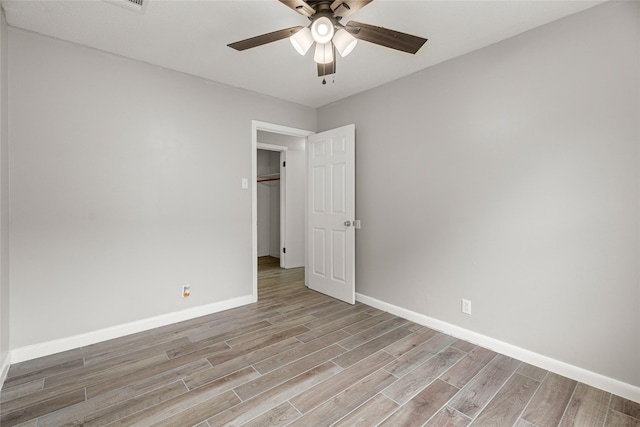 unfurnished bedroom with light wood-style flooring, baseboards, and a ceiling fan