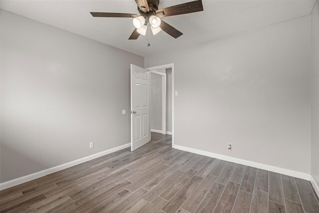unfurnished room with wood finished floors, ceiling fan, and baseboards