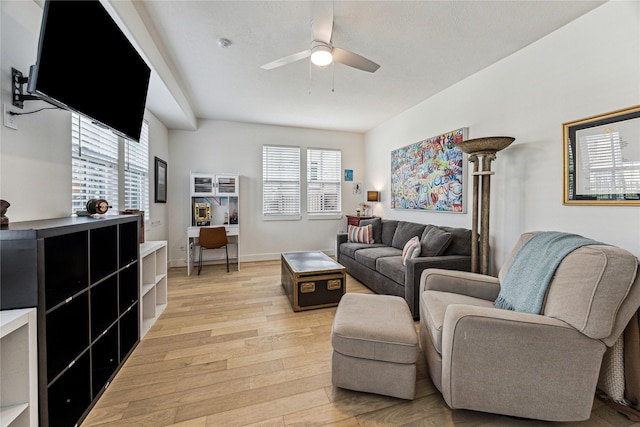 living room with light wood-style floors, a ceiling fan, and baseboards