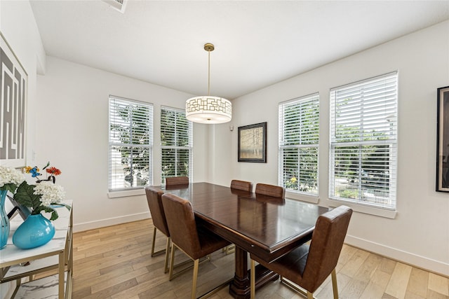 dining space featuring healthy amount of natural light, light wood-type flooring, and baseboards