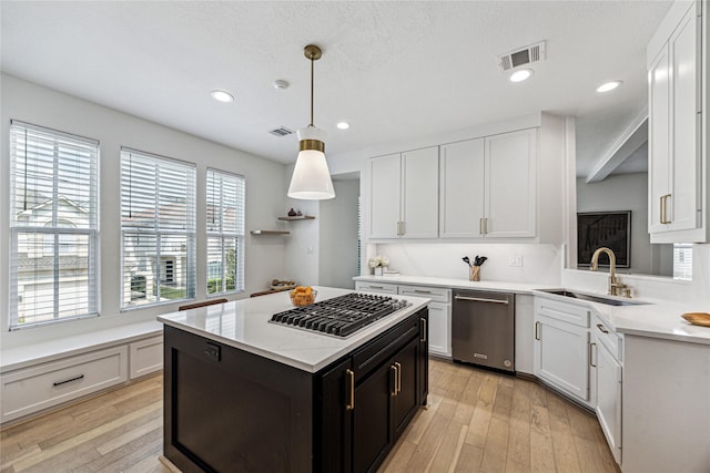 kitchen featuring appliances with stainless steel finishes, a sink, light wood-type flooring, white cabinetry, and recessed lighting