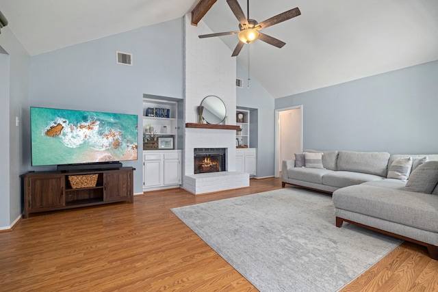 13 Leverwood Ct, The Woodlands, TX 77381 - living area featuring high vaulted ceiling, ceiling fan, wood finished floors, beam ceiling, and a brick fireplace