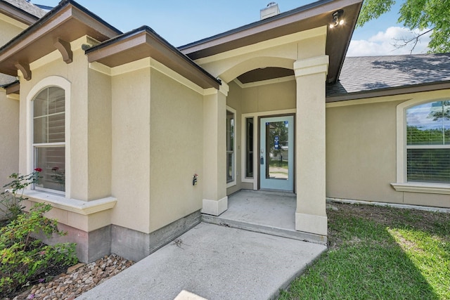 12885 Andromeda Ct, Willis, TX 77318 - view of exterior entry with a shingled roof and stucco siding