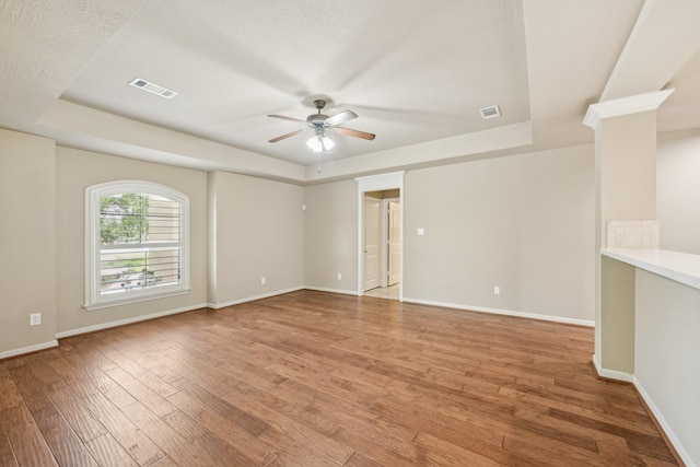 12885 Andromeda Ct, Willis, TX 77318 - unfurnished room featuring a tray ceiling, ceiling fan, light wood-type flooring, and baseboards