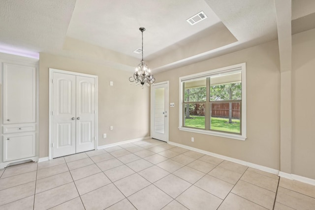 12885 Andromeda Ct, Willis, TX 77318 - empty room with a tray ceiling, a chandelier, light tile patterned floors, and baseboards