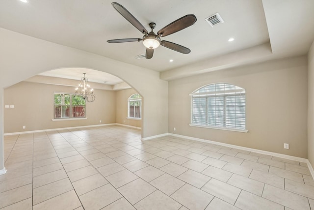 12885 Andromeda Ct, Willis, TX 77318 - spare room featuring a ceiling fan, a chandelier, light tile patterned floors, arched walkways, and a tray ceiling