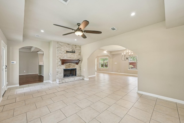 12885 Andromeda Ct, Willis, TX 77318 - unfurnished living room featuring light tile patterned floors, ceiling fan, a stone fireplace, arched walkways, and recessed lighting