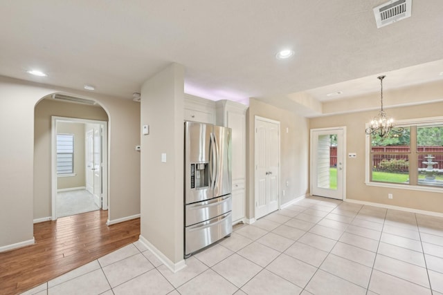 12885 Andromeda Ct, Willis, TX 77318 - spare room featuring arched walkways, light tile patterned flooring, recessed lighting, baseboards, and a chandelier
