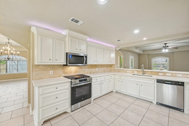 12885 Andromeda Ct, Willis, TX 77318 - kitchen featuring stainless steel appliances, a sink, light tile patterned floors, decorative backsplash, and recessed lighting
