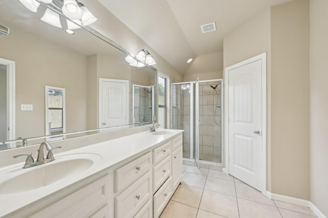12885 Andromeda Ct, Willis, TX 77318 - full bathroom featuring a stall shower, tile patterned flooring, vaulted ceiling, double vanity, and baseboards