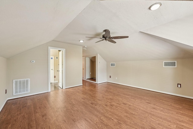 12885 Andromeda Ct, Willis, TX 77318 - bonus room featuring wood finished floors, vaulted ceiling, a ceiling fan, baseboards, and a textured ceiling