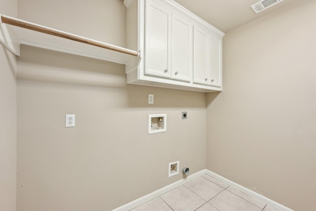 12885 Andromeda Ct, Willis, TX 77318 - laundry area with hookup for an electric dryer, washer hookup, cabinet space, baseboards, and light tile patterned floors