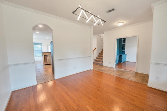 12139 Canyon Arbor Way, Houston, TX 77095 - unfurnished room with ornamental molding, wood finished floors, stairway, arched walkways, and baseboards