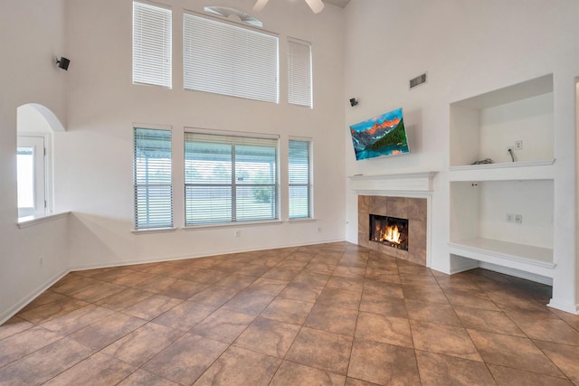 12139 Canyon Arbor Way, Houston, TX 77095 - unfurnished living room with a towering ceiling, a tile fireplace, baseboards, and a ceiling fan