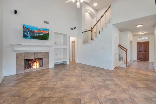 12139 Canyon Arbor Way, Houston, TX 77095 - unfurnished living room with stairs, built in shelves, ceiling fan, a towering ceiling, and baseboards
