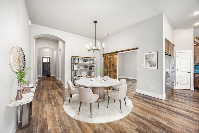 7114 Clubtail Rd, Katy, TX 77493 - dining space with arched walkways, a barn door, a chandelier, dark wood-type flooring, and baseboards
