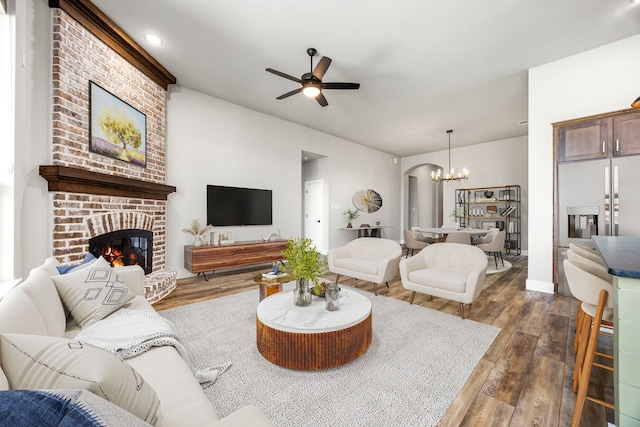 7114 Clubtail Rd, Katy, TX 77493 - living room featuring dark wood-type flooring, a chandelier, a ceiling fan, and a fireplace