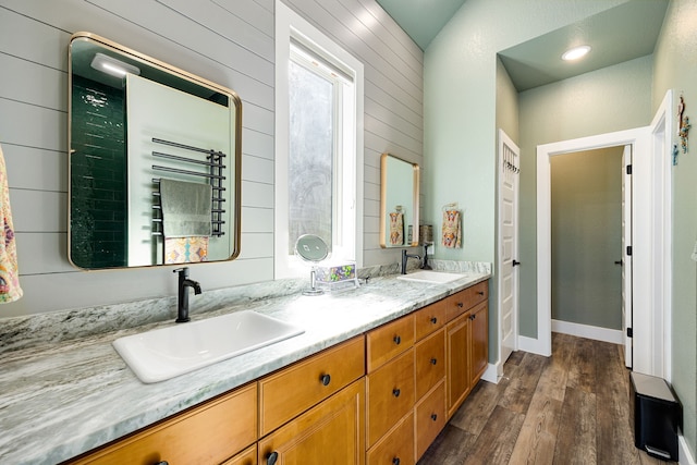 7114 Clubtail Rd, Katy, TX 77493 - full bathroom featuring wood finished floors, double vanity, wooden walls, and a towel warming rack