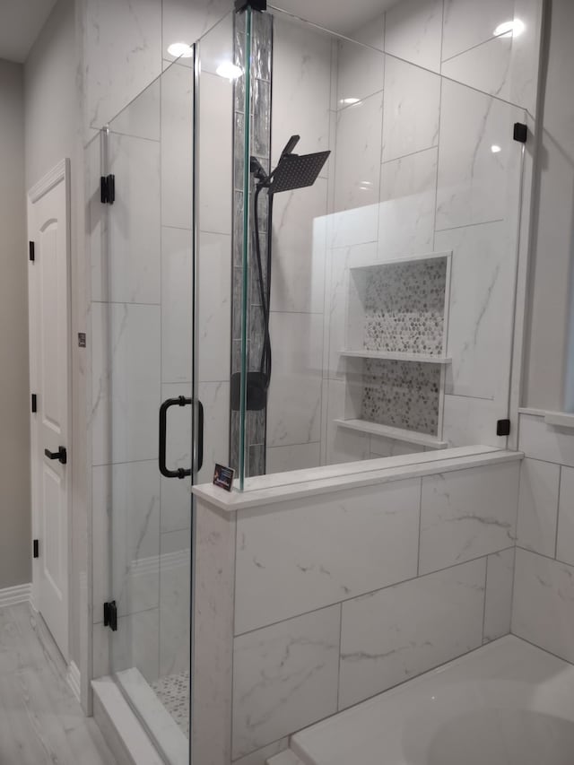 full bath with a shower stall and marble finish floors