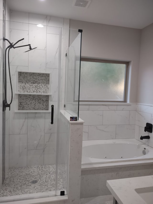 full bathroom with a jetted tub, a shower stall, and vanity