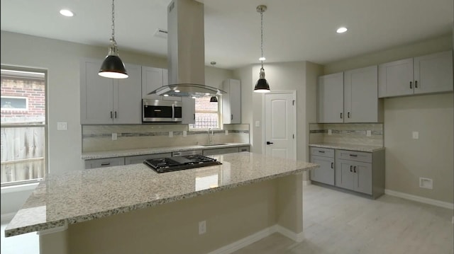 2716 Garapan St, Houston, TX 77091 - kitchen featuring stainless steel microwave, tasteful backsplash, black stovetop, a sink, and island range hood