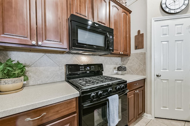 kitchen featuring black appliances, decorative backsplash, light countertops, and light tile patterned floors
