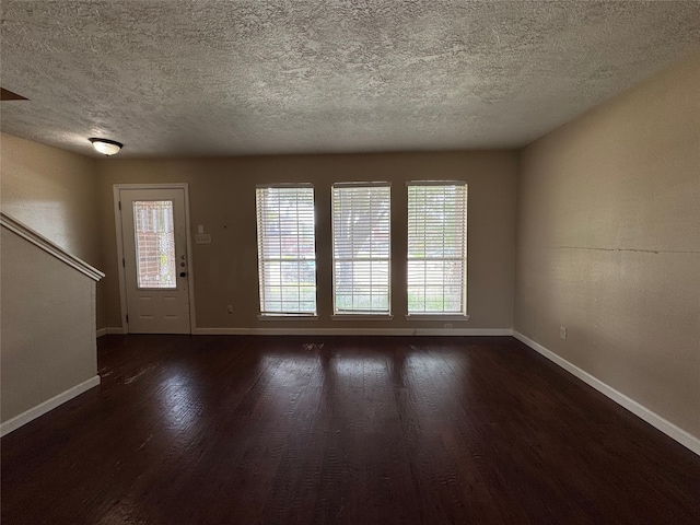 3505 Stonegate Cir, Pearland, TX 77584 - unfurnished living room with baseboards, dark wood-style floors, plenty of natural light, and a textured ceiling