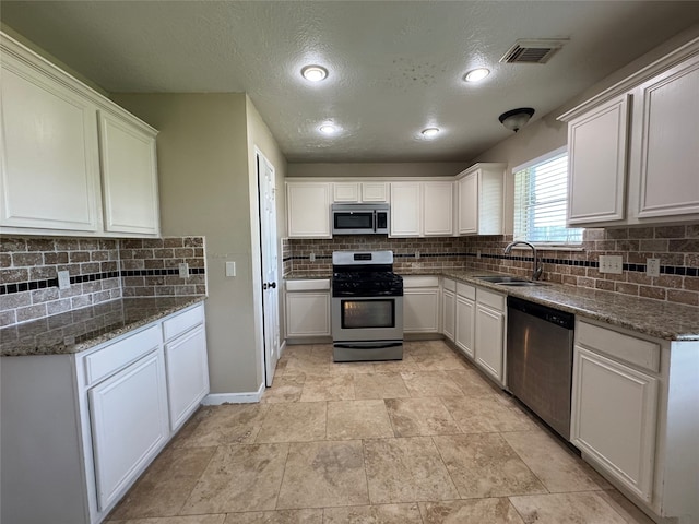3505 Stonegate Cir, Pearland, TX 77584 - kitchen with stainless steel appliances, a sink, tasteful backsplash, a textured ceiling, and white cabinetry