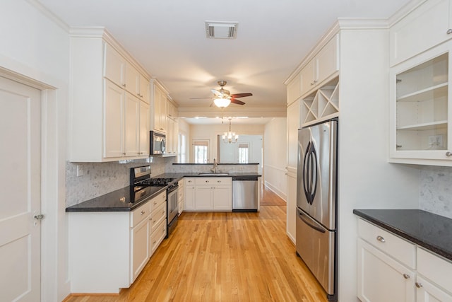 1510 W 21st St, Houston, TX 77008 - kitchen with stainless steel appliances, a peninsula, ceiling fan, light wood-style flooring, and dark countertops