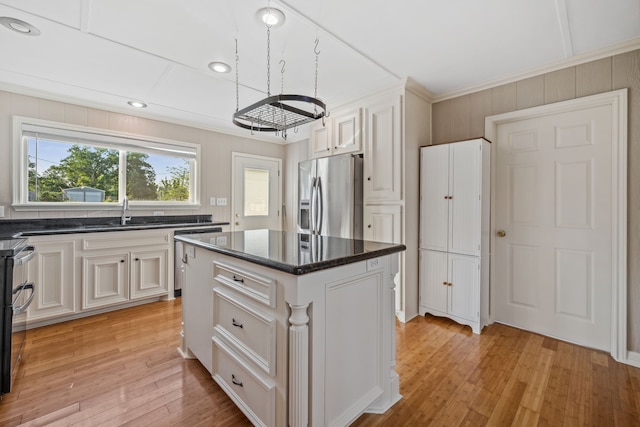 381 N Shady Oaks Dr, Point Blank, TX 77364 - kitchen featuring appliances with stainless steel finishes, a sink, light wood-style floors, a center island, and crown molding