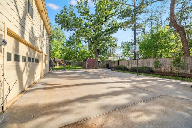 view of patio featuring fence, a storage shed, and an outbuilding