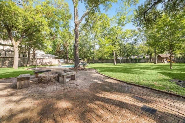 surrounding community featuring a playground, a patio area, and an outdoor fire pit