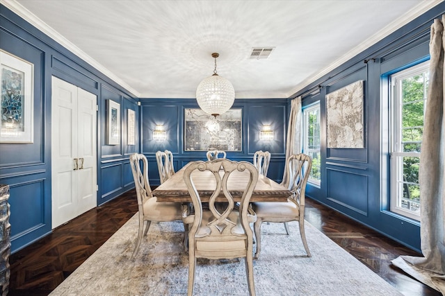 dining area with a decorative wall, crown molding, and baseboards