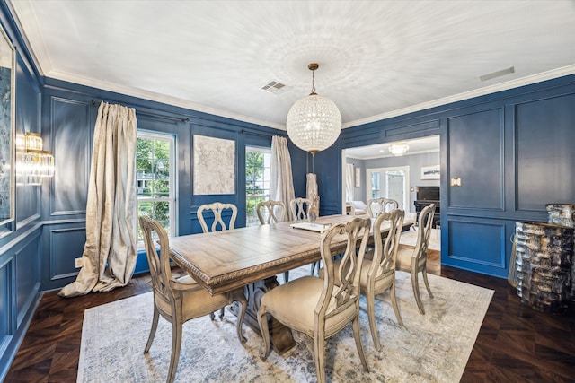 dining area featuring a decorative wall, crown molding, and a chandelier