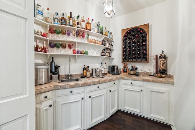 indoor wet bar featuring dark wood-style floors