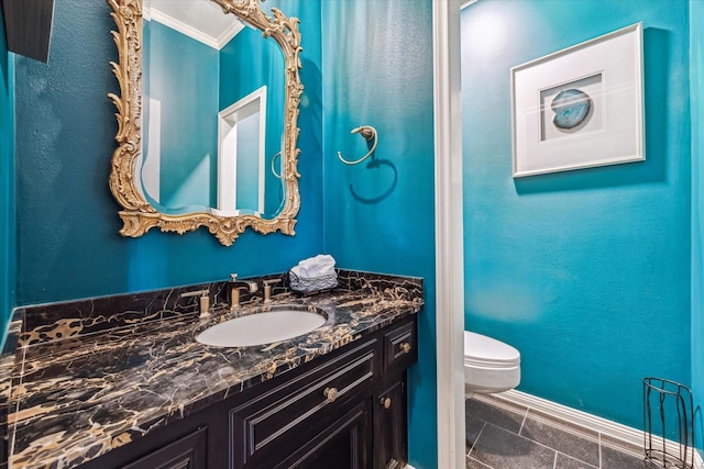 half bath with baseboards, toilet, vanity, ornamental molding, and tile patterned floors