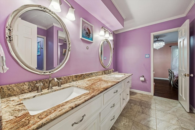 bathroom featuring crown molding, double vanity, baseboards, and marble look tiles