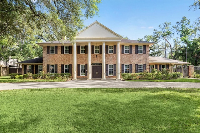 neoclassical home with a front lawn and brick siding