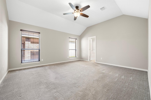 spare room featuring lofted ceiling, ceiling fan, carpet flooring, and baseboards